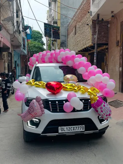 We also offer car decorations to welcome the new baby. This car is decorated with pink and white balloons and 'It's a Girl' foil balloons.