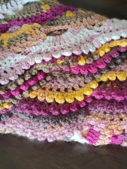 This folded view of the Virus Shawl highlights the rich texture and layers of color. The combination of pinks, yellows, and browns in this yarn is just gorgeous.