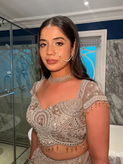 A full look at this bride's reception attire. The makeup is soft and romantic, complementing the intricate details of her lehenga and jewelry.