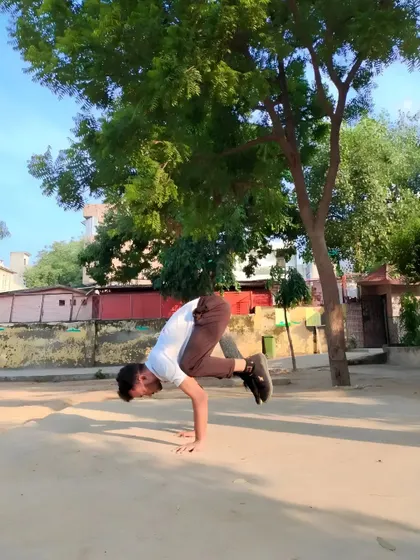 Practicing Vakasana (Crow Pose). This balancing asana is great for strengthening the shoulders and arms, and it significantly improves concentration and balance.