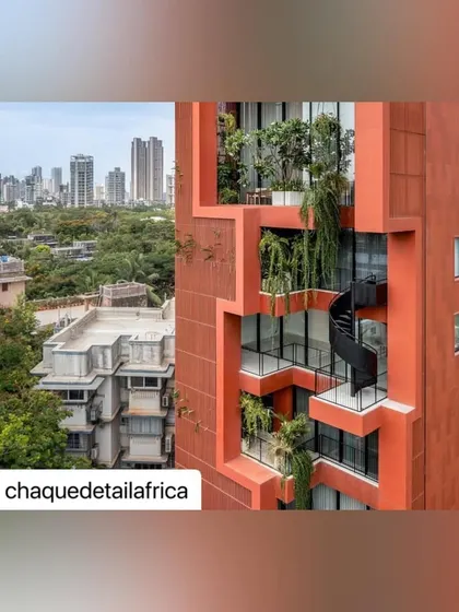 A close-up view of the interlocking terraces and the black spiral staircase, highlighting the dynamic geometry and the pockets of green that define the building's facade.