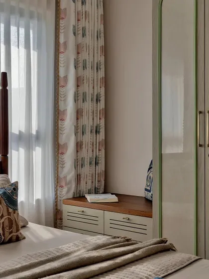 This bedroom is a cozy retreat designed for comfort and nostalgia. The classic four-poster wooden bed, patterned curtains, and soft, layered linens create a warm and welcoming ambiance, perfect for a grandparents' room.