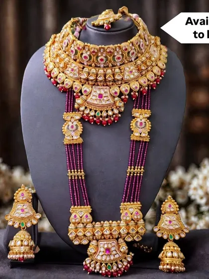 A royal bridal set from my exclusive sale collection, featuring a stunning choker and a multi-layered rani haar with deep red beads. The matching jhumkas complete this opulent wedding look.