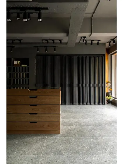 The showroom features custom-designed storage and display units. Here, a large wooden chest of drawers sits in front of a slatted screen, demonstrating different ways to use wood and veneer.