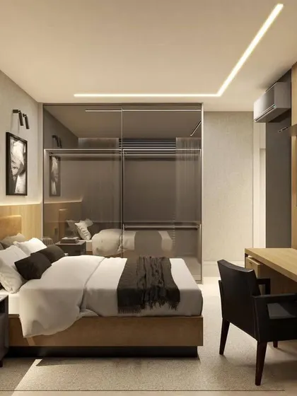 This bedroom design includes a compact study desk and TV unit, making it a multi-functional space. The mirrored wardrobe door enhances the sense of space.