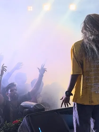 Looking out at a sea of hands in the air, with smoke and light creating a powerful concert-like feel.