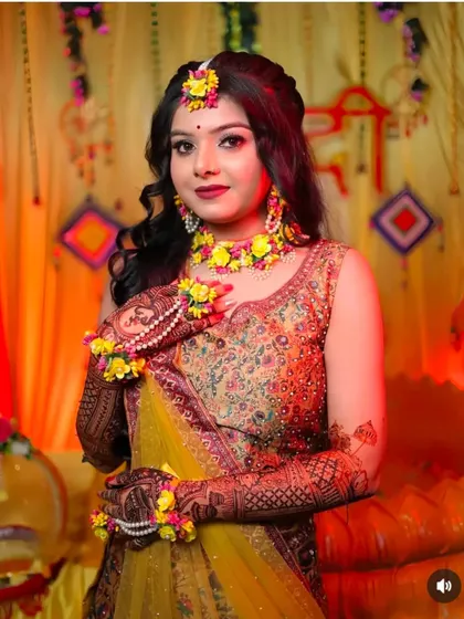 A bride looking radiant with her floral jewelry and full bridal mehndi.