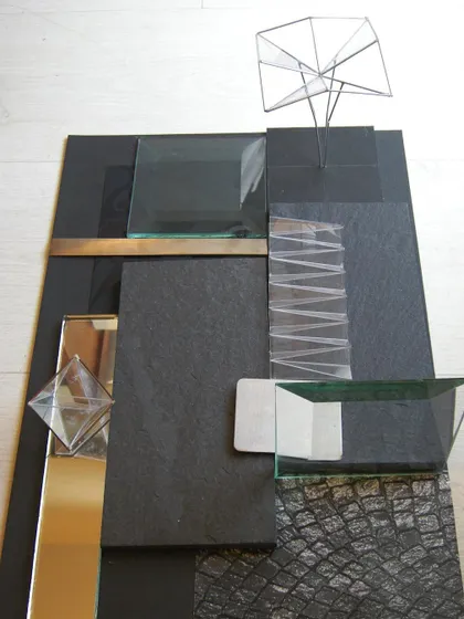 This material mood board for the ORRA jewellery store shows our curated palette of black stone, textured wallpaper, glass, and mirror. These materials were orchestrated to create a sense of dark mystery and subtle richness, providing the perfect backdrop for glowing diamonds.