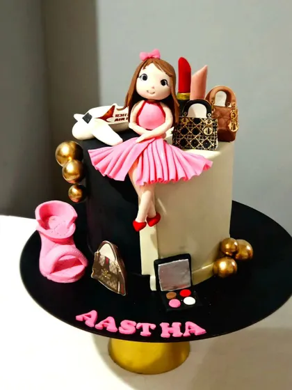 The full topper arrangement for the "favorite things" cake, featuring the custom figurine surrounded by miniature edible versions of her favorite luxury bags, lipstick, and makeup palette.