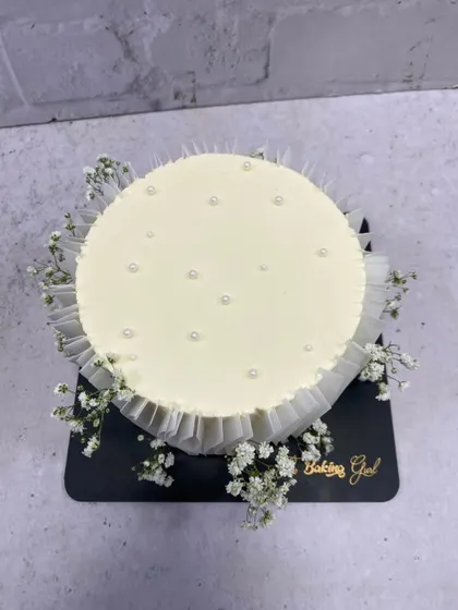 A top-down view showing the simple pearl details on this elegant white cake.