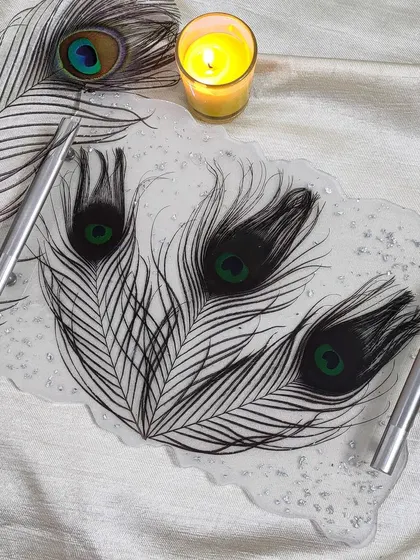 This elegant resin tray was made using real peacock feathers and a sprinkle of silver flakes. It's perfect for holding your favorite perfumes or jewelry and adds a unique touch to any space.