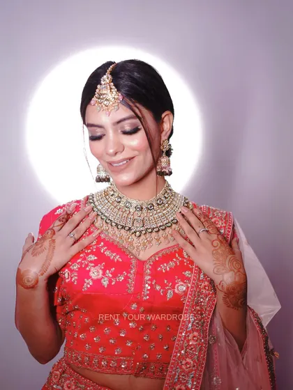 A close-up of our other pink lehenga, showing the detailed embroidery and henna-adorned hands.