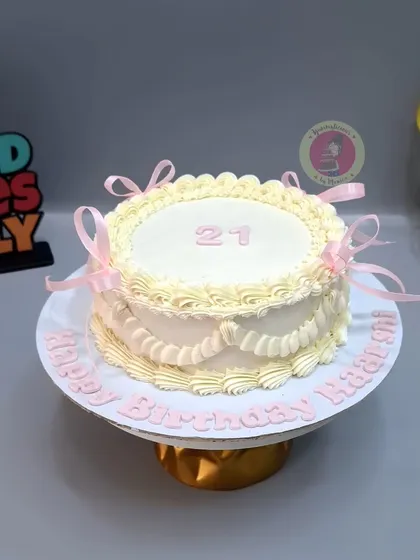 An elegant vintage cake with delicate piping and soft pink ribbons.