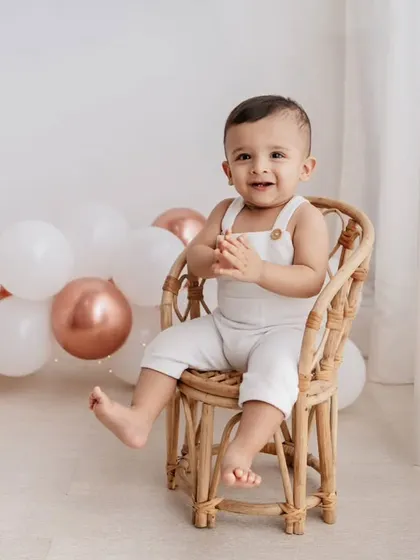 A classic seated portrait for a first birthday. This little one looks so proud sitting in his mini rattan chair, ready to celebrate.