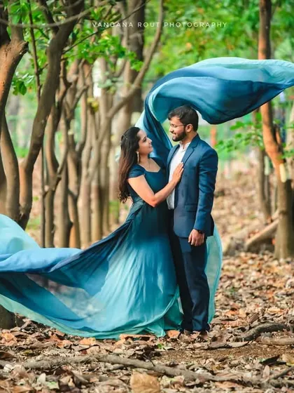 The forest becomes a ballroom in this enchanting shot. The movement of the long, flowing trail of the gown adds a dynamic and whimsical element to this nature-based pre-wedding photo.