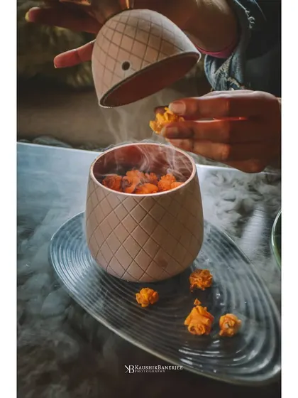 A theatrical presentation of frozen popcorn with liquid nitrogen smoke. This shot captures a unique dining experience, perfect for restaurants that want to highlight their molecular gastronomy dishes.