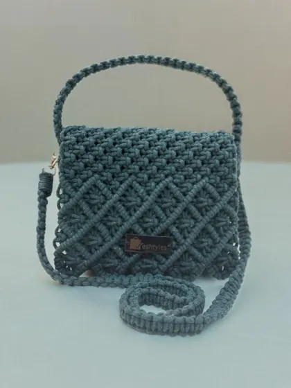 A small and chic grey sling bag with a diamond knot pattern. It's compact but makes a big style statement.