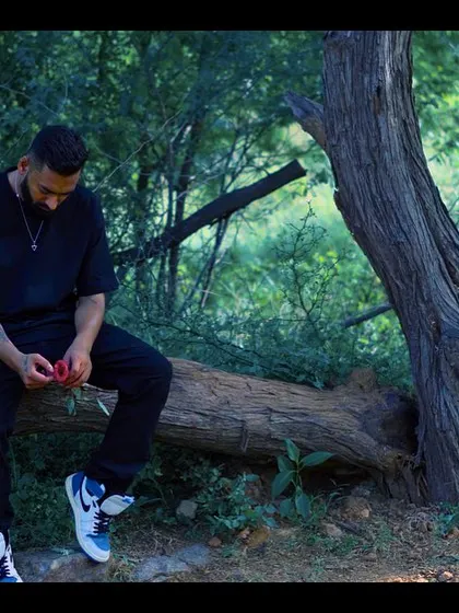 A shot of me sitting with a rose from the 'Kurbaan Hua' video. This visual captures a moment of quiet contemplation and heartbreak, central to the song's theme.