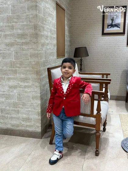 A casual pose in a not-so-casual jacket. The vibrant red velvet and polka-dot details make this a standout piece for any occasion.