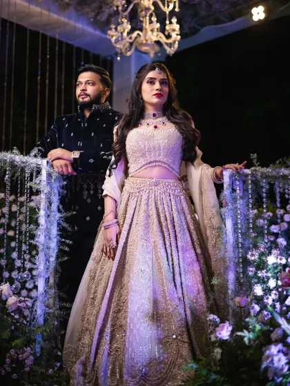 A power portrait of the couple, Mahima and Rohaanth. Mahima's makeup is strong and sophisticated, matching the formal and elegant tone of the photograph.