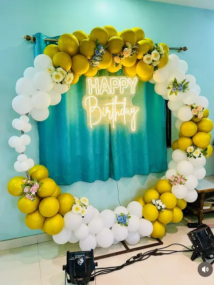 A complete shot of the yellow and white floral-accented balloon ring, ready for a birthday celebration.