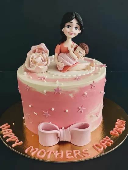 A beautiful cake to honor a special woman on Mother's Day, featuring a touching topper of a mother holding her baby.