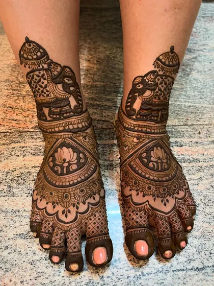 A majestic elephant design for bridal feet mehendi. The pattern features a large, decorated elephant on each ankle, with intricate work extending down to the toes.