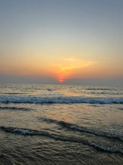 A serene shot of the waves and the sunset over the Arabian Sea.