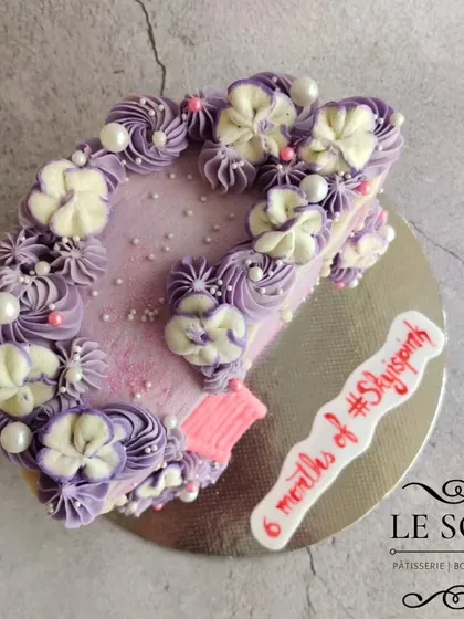 Half cakes are perfect for celebrating six-month milestones. This half-kg Ferrero Crunch cake features a pretty purple ombre, a white chocolate drip, and a cute pink ladder.