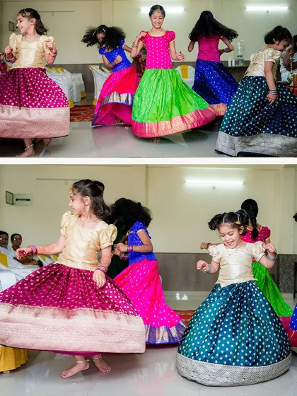 The vibrant colors of traditional skirts (lehengas) twirling as young girls dance and play during a thread ceremony celebration.