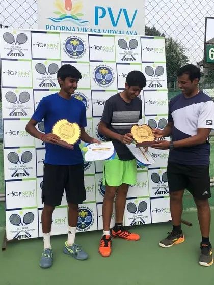 A coach presenting the winners' trophies to our U-18 doubles champions.