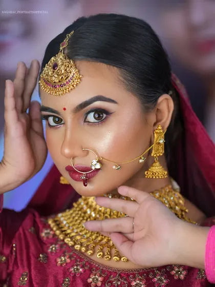 A close-up from a masterclass, demonstrating a North Indian bridal look. The focus is on creating a flawless, glowing base and defining the eyes with kohl and a sharp wing.