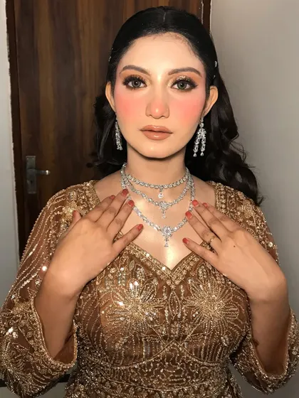 A close-up of the "Golden Girl" look, focusing on the flawless skin and layered diamond necklaces.