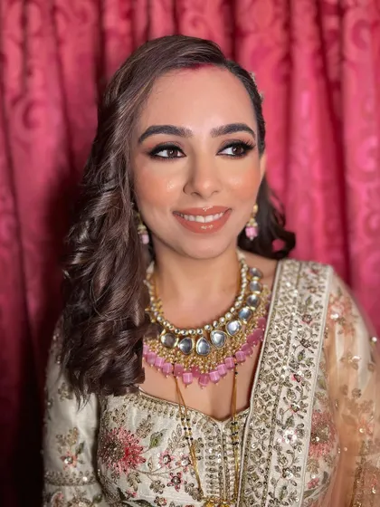 This angle highlights the glossy lip and the radiant highlighter on her cheekbones.