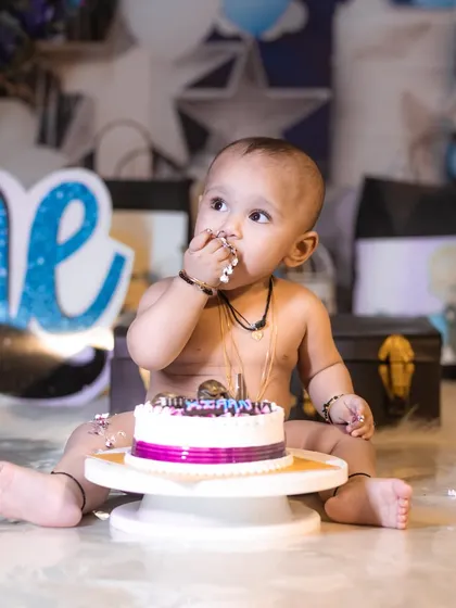 A candid moment of a baby boy tasting his birthday cake for the first time during his studio cake smash session.