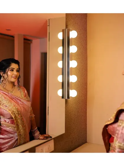 The bride looking at her reflection, a moment of final touches before her engagement ceremony. The image captures her anticipation and excitement.
