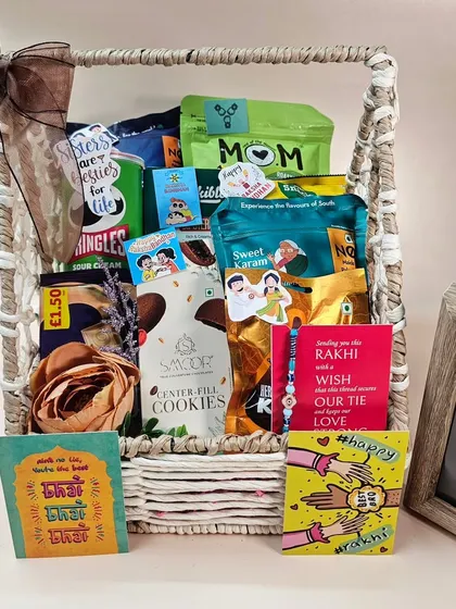 A Rakhi hamper focused on delicious treats. This woven basket is filled with a variety of snacks, cookies, and chocolates, perfect for a sibling who is a true foodie.