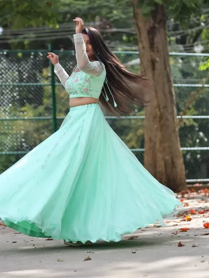 A beautiful shot of a client mid-twirl in her light green lehenga, showing the wonderful movement and flare of the skirt.