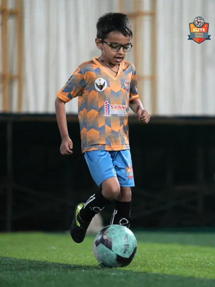A player carefully dribbles the ball, focusing on keeping it close to his feet.