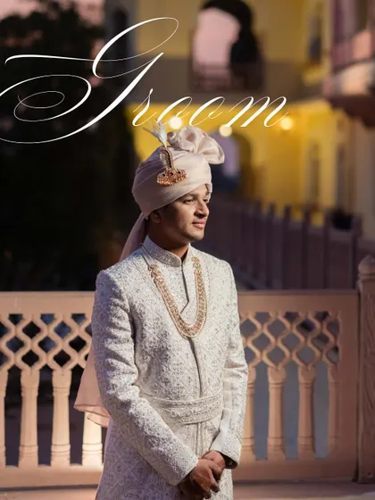 A classic groom portrait at dusk. The soft lighting and elegant pose capture the groom's sophisticated style against the beautiful architectural backdrop.