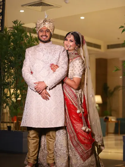 A full-length portrait of the bride and groom in their wedding attire, showcasing their coordinated outfits.