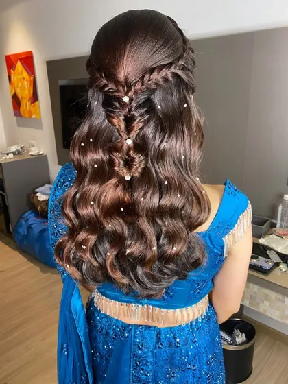 A creative half-updo with a fishtail braid detail and soft waves, dotted with pearls for a touch of elegance.