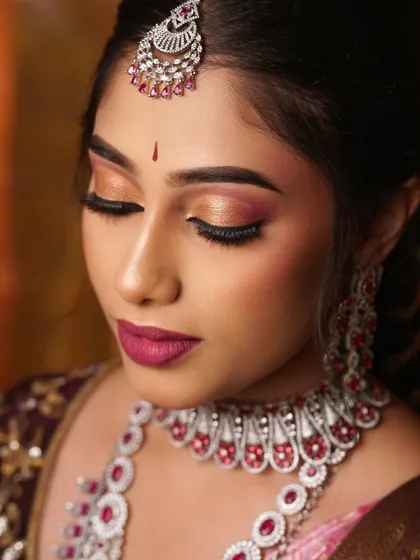 A detailed close-up of the eye makeup. You can see the blend of warm tones and a touch of shimmer on the lid, paired with a bold winged liner.