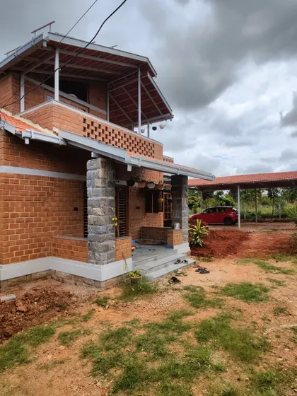 This perspective shows the main house along with the covered carport, demonstrating how we integrate practical structures into the overall design. The consistency in roofing and materials creates a cohesive property.