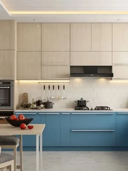 This L-shaped kitchen pairs glossy blue base cabinets with light wood-grain upper cabinets. A small table at the end provides a convenient spot for casual meals.