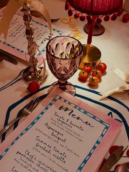 The charming, Italian-inspired place setting, complete with a custom menu, colored glassware, and a miniature table lamp, creating a cozy and intimate feel.