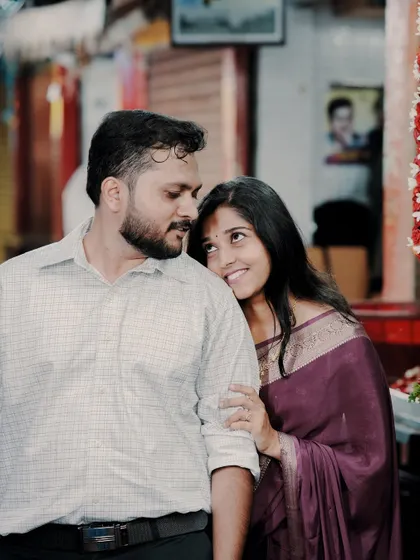 An intimate and sweet moment with the bride leaning on the groom's shoulder, captured in the warm, ambient light of a city market at dusk.