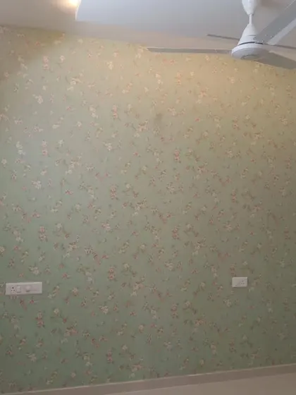 A room with a light green wallpaper featuring a small, delicate floral pattern, perfect for a subtle touch of color.