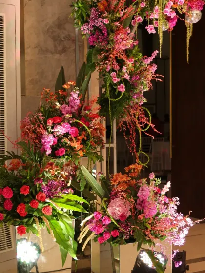 An asymmetrical floral arrangement on a mirrored stand, part of the dynamic and colorful decor for the retro-themed party.