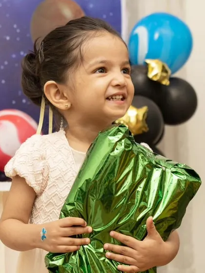 The pure excitement of receiving a gift. This candid shot captures the birthday girl's delight, a perfect memory from her special day.